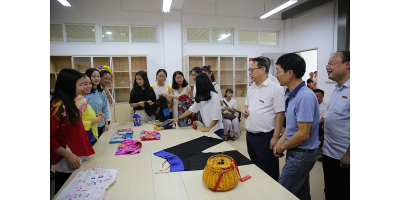 在纺织与服装学院，屈校长与浔埔女服饰第八代传承人黄晨师傅交流